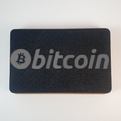 Couvercle de l'étui Trezor fermé - logo bitcoin gravé en relief sur le dessus