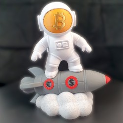 Statuette astronaute Bitcoin vue de face - visière dorée au logo BTC, chevauchant une fusée grise